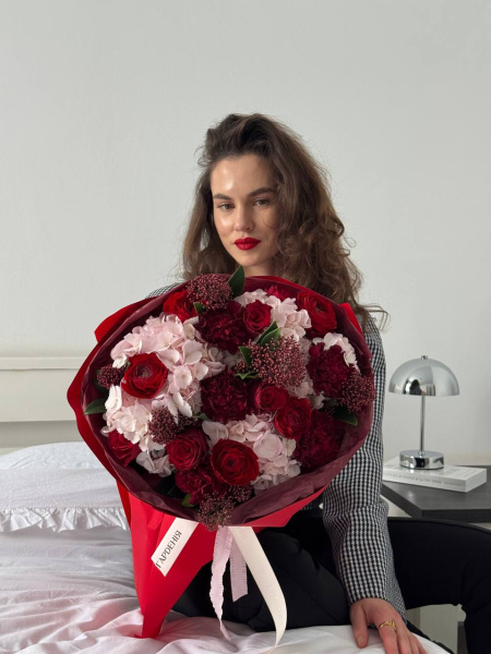 Букет з червоних троянд, ранункулюсів та ніжно-рожевої гортензії у червоному пакуванні
